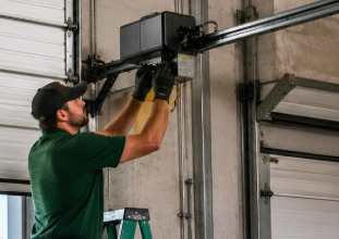 Technician servicing a commercial garage door operator at a Los Angeles warehouse